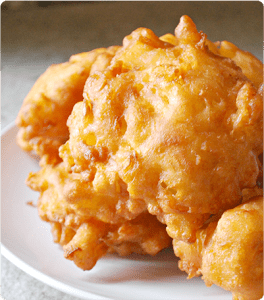 Several Honey Cornbread Fritters on a white plate.