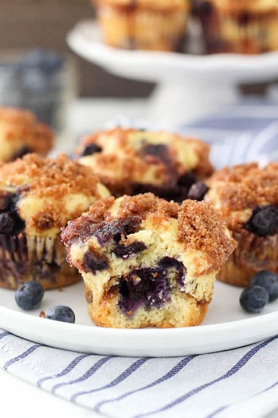 A plate of Gluten Free Blueberry Coffee Cake muffins garnished with blueberries.