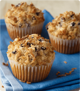 Three Coconut and Blueberry Crunch Almond Muffins on a blue dish towel.