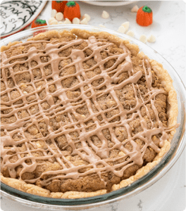 A delicious pumpkin cookie pie sits in a glass pie dish on a white kitchen counter.