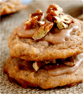 A stack of two Pumpkin White Chocolate Pecan Cookies sit on a woven placemat.