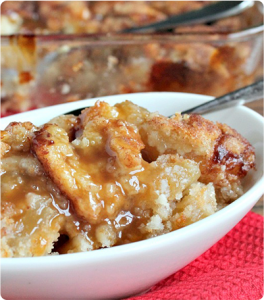 A bowl of Snickerdoodle Cobbler with apple pie filling and caramel topping.