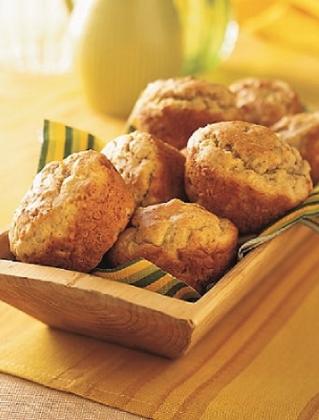 Several Delish Basic Muffins sit in a wooden serving dish.