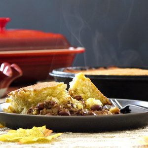 A serving of Chili Cornbread Pot Pie sits on a gray plate.