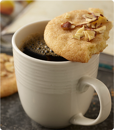 Almond Doodle cookie resting on top of a cup of coffee.