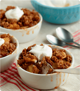 A bowl of Apple Crunch topped with vanilla ice cream and whipped cream.
