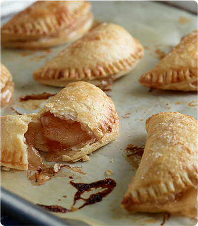 A baking sheet with freshly baked Apple Pocket Pies.