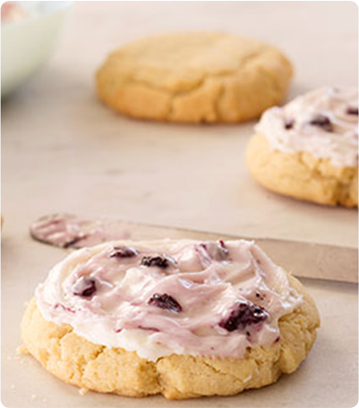 Three Blueberry Frosted Cookies on a counter.