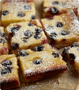 Freshly baked Blueberry Lemon Cream Bars topped with powdered sugar.