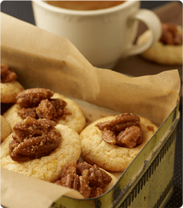 A metal tin full of Candied Pecan Thumbprints.