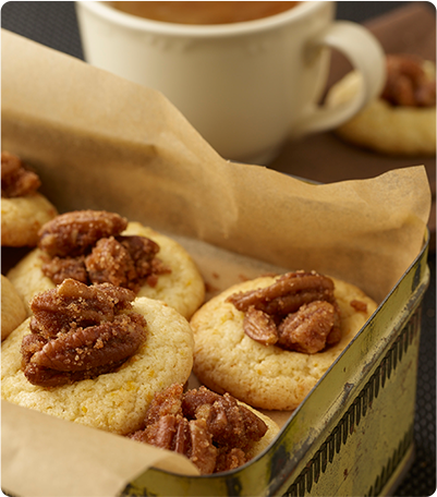 A metal tin full of Candied Pecan Thumbprints.