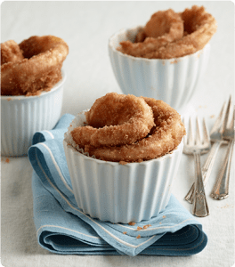 Three Cinnamon Sugar Roll-Ups in individual muffin tins with forks and napkins.