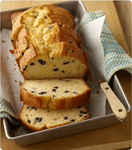 A Citrus Blueberry Loaf cut into several slices on a baking sheet.