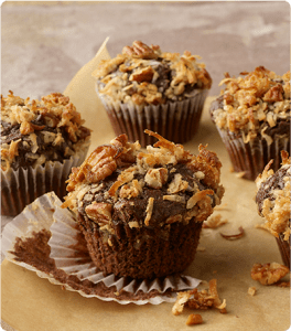 Several German Chocolate Muffins sit on parchment paper.