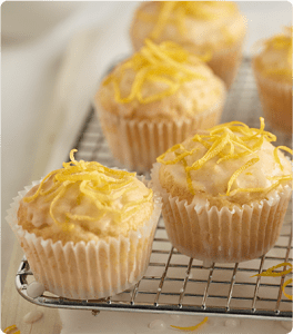 Several Lemonade Cupcakes resting on a cooling rack.