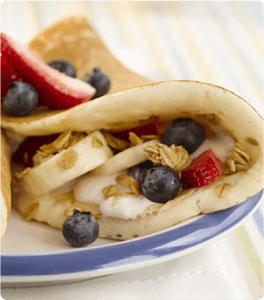 A Pancake Turnover filled with yogurt, granola, bananas, blueberries and strawberries.