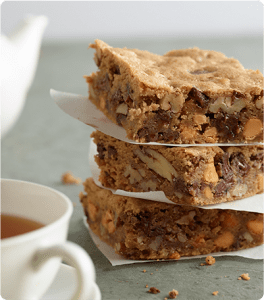 A stack of Pecan Blondies with each layer separated by parchment paper.