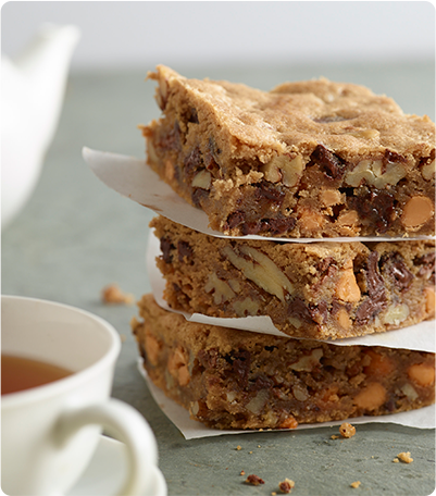 A stack of Pecan Blondies with each layer separated by parchment paper.