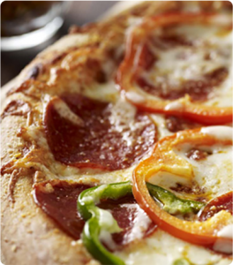 A Sourdough Pizza topped with pepperoni, red and green bell peppers.