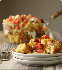 A plate of Tennessee Cornbread Salad with chopped tomatoes, celery, onions, sweet pickles and cooked bacon.