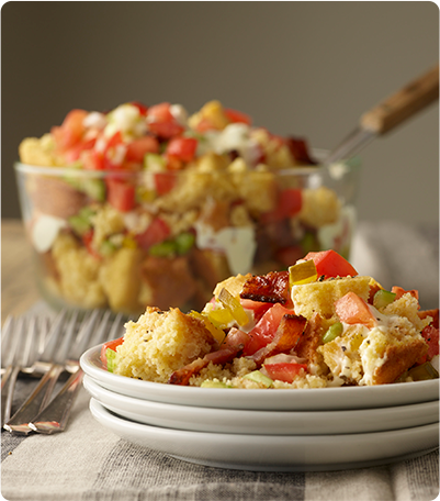 A plate of Tennessee Cornbread Salad with chopped tomatoes, celery, onions, sweet pickles and cooked bacon.