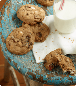 A plate of White Chocolate Cranberry Cookies paired with a glass of milk.
