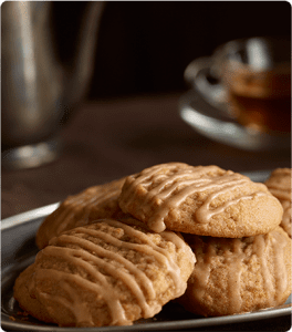 A plate of Zesty Pumpkin Cookies topped with spiced vanilla glaze.