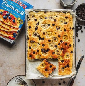 A baking sheet of Chocolate Banana Sheet Pan Pancakes with a couple slices cut out.