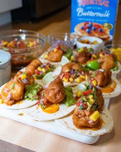 A platter of Beer Battered Shrimp/ Fish Tacos topped with mango salsa.