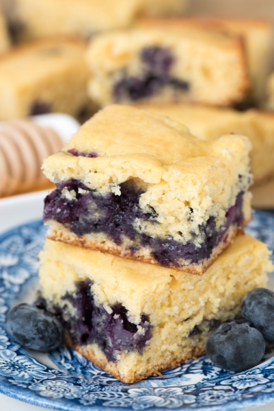 Two slices of Blueberry Cornbread stacked on a decorative blue plate.