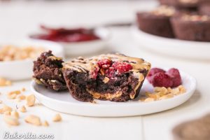 A Gluten-Free Peanut Butter and Jelly Brownie Bite with a bite taken out on a plate.