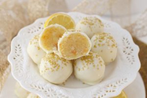 A plate of Lemon Cake Truffles topped with gold and white sprinkles.