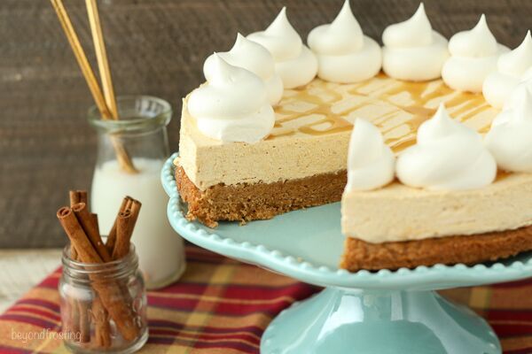 A Pumpkin Cheesecake Cookie Pie, with a slice cut out of it, sits on a light blue cake platter.