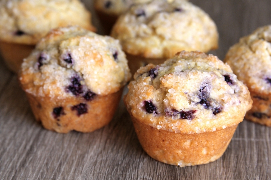 Several blueberry muffins topped with large sugar crystals.