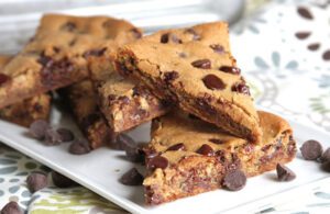 Slices of Giant Triple Chocolate Chunk and Citrus Cookies on a white serving dish.