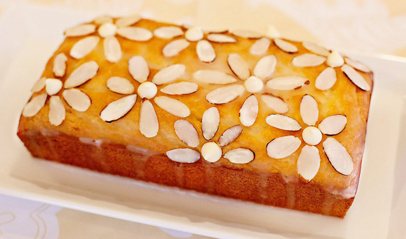 A loaf of Lemon-Almond Pound Cake with Almond Flower Glaze on top.