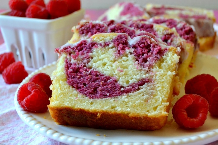 Slices of Raspberry Lemon Pound Cake on a plate garnished with raspberries.