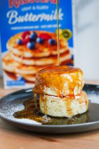 Syrup being poured onto a stack of Fluffy Soufflé Pancakes.