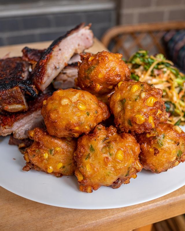 A stack of Corn Fritters on a white plate.