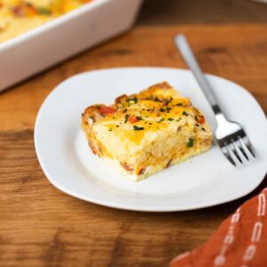 A slice of Breakfast Casserole on a plate with a fork.