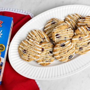 A platter of Cranberry Orange Cookies drizzled with white chocolate.