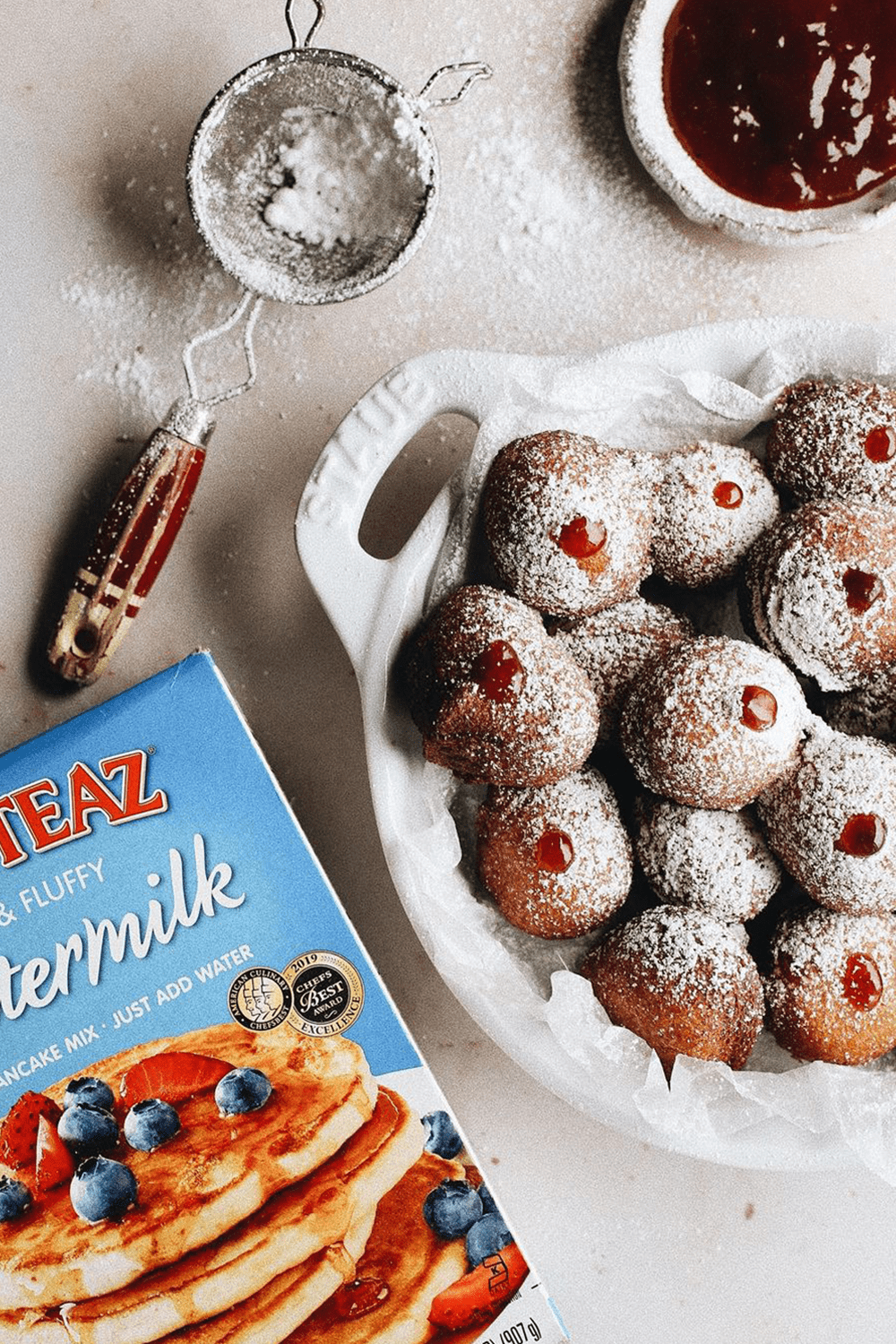 A platter of Drop Donuts topped with powdered sugar.