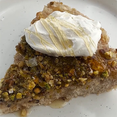 A slice of Baklava Skillet Pancakes topped with honey and creme fraiche.