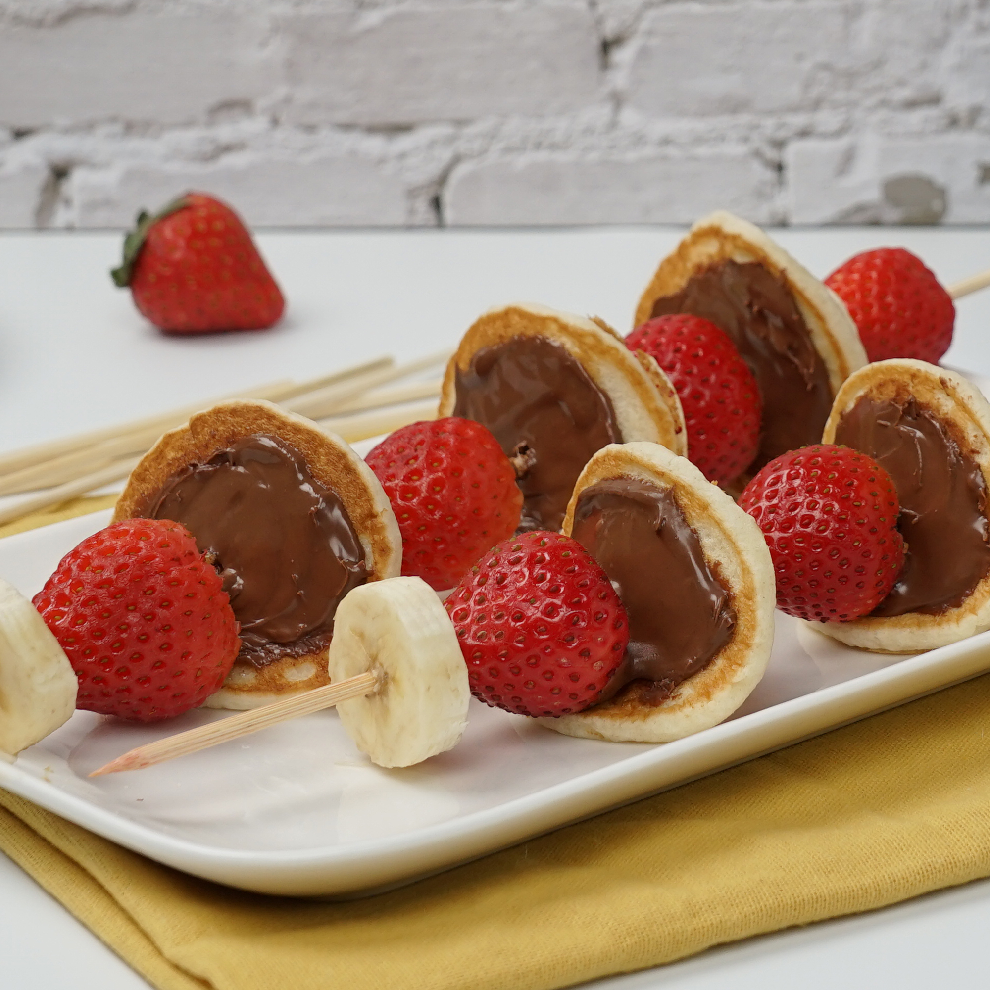 A plate of Pancake Skewers with Nutella® Hazelnut Spread, bananas and strawberries.