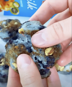 A Mini Streusel Blueberry Muffin being torn in half.