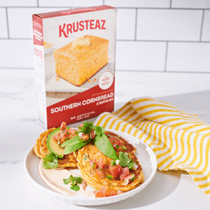 A plate of Savory Chili Corn Cakes topped with avocado and pico de gallo.