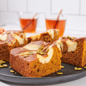 A plate of Pumpkin Spice Cheesecake Snack Cakes topped with pumpkin seeds.