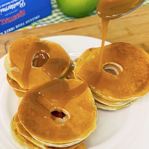 Three stacks of Apple Fritter Bites being drizzled with syrup.