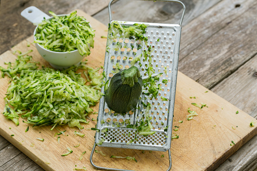 A close up shot of two cups of grated zucchini.